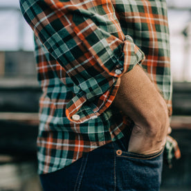 Fit model with sleeves rolled up and hands in pocket of The Jack in Rust Plaid Oxford