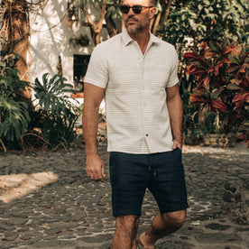 fit model wearing The Apres Short in Navy Hemp, hand in pocket, sunglasses on