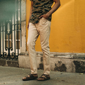 fit model wearing The Camp Pant in Khaki Herringbone, against yellow wall