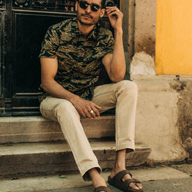 fit model wearing The Camp Pant in Khaki Herringbone, sitting on steps