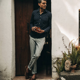 fit model wearing The Easy Pant in Navy Herringbone, drinking coffee