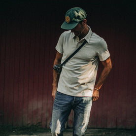 fit model wearing The Heavy Bag Polo in Natural and Ash Stripe, near red barn