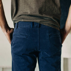 material shot of The Atelier and Repairs Chino in Navy, model facing opposite of camera, back shot