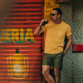 fit model wearing The Trail Short in Rain Drop Camo, drinking a coke