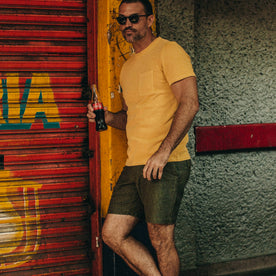 fit model wearing The Trail Short in Rain Drop Camo, holding coke