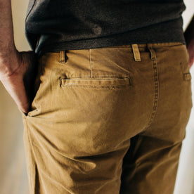 material shot of The Atelier and Repairs Chino in British Khaki, model wearing chinos—back detail