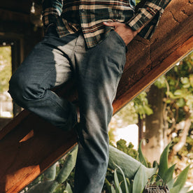 fit model wearing The Camp Pant in Coal Boss Duck, sitting on beam 
