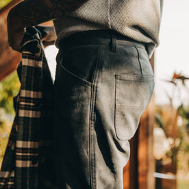 fit model wearing The Camp Pant in Coal Boss Duck, side shot, holding shirt