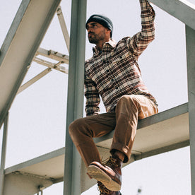 fit model wearing The Crater Shirt in Ivory Plaid, sitting on beam