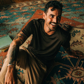 fit model wearing The Merino Tee in Heather Espresso, smiling, looking right