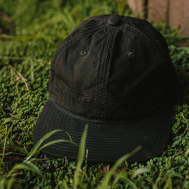 fit model threw the The Ball Cap in Espresso Dry Wax on the ground