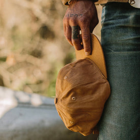 fit model holding by his side The Ball Cap in Tobacco Boss Duck