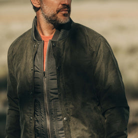 fit model wearing The Bomber Jacket in Waxed Olive looking over shoulder