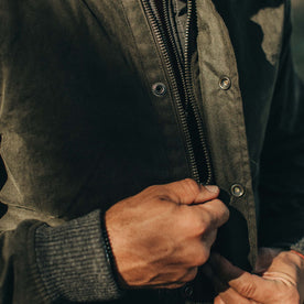 fit model zipping up front of The Bomber Jacket in Waxed Olive
