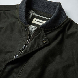 material shot of The Bomber Jacket in Waxed Olive from the front showing label and collar