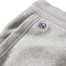 material shot of the embroidered logo on the side pocket of The Fillmore Pant in Ash Double Knit