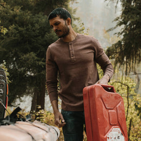 fit model wearing the heavy bag, holding gas can