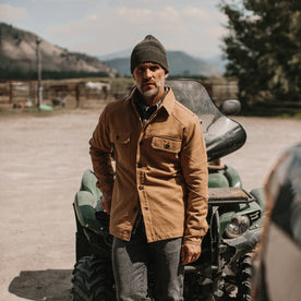 fit model wearing The Lined Shop Shirt, looking into camera next to atv