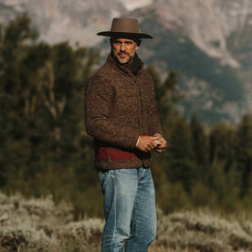 fit model wearing The Port Jacket in Espresso Marl, holding rock