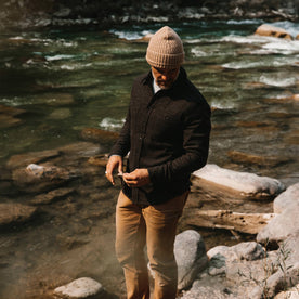 fit model wearing The Service Shirt in Moss Melange Wool, looking down in creek