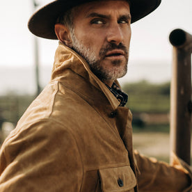 fit model wearing The Lined Long Haul Jacket in Sand Suede looking over his right shoulder