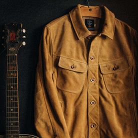 material shot of The Lined Long Haul Jacket in Sand Suede hanging up