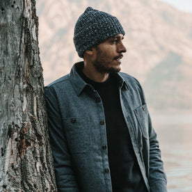 Fit Model wearing The Waffle Beanie in Indigo Marl Merino leaning up against a tree