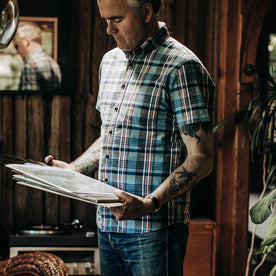 Fit model wearing shirt and looking at records in house