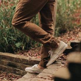 our fit model wearing The Après Pant in British Khaki Seersucker—walking down stairs, cropped from thigh down