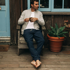 our fit model wearing The Après Pant in Navy Seersucker—sitting on chair