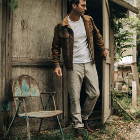 our fit model wearing The Chore Pant in Ash Boss Duck—walking out of shed