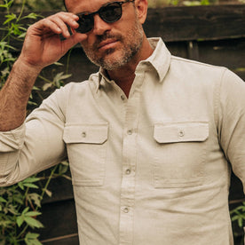 fit model wearing The Chore Shirt in Natural Herringbone, sunglasses on, looking at camera