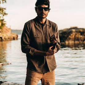 our fit model wearing The Corso in Walnut Double Cloth—standing next to water