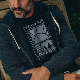 our fit model wearing The Heavy Bag Tee in Retro Block Print—cropped shot laying down