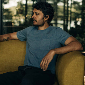 our fit model wearing The Heavy Bag Tee in Slate—siting down