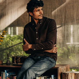 our fit model relaxing in The Jack in Brushed Rust Oxford—sitting, looking right