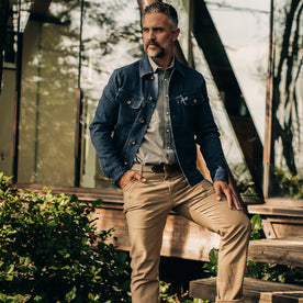 The Long Haul Jacket in Indigo Boss Duck—standing next to cabin