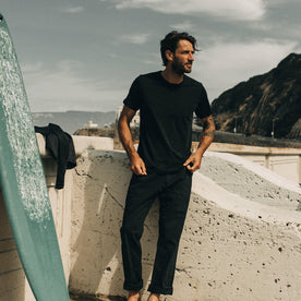 our fit model wearing The Merino Tee— on the beach, in our black colorway 