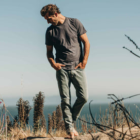 our fit model wearing The Standard Issue Tee in Navy Hemp—outside on the beach walking