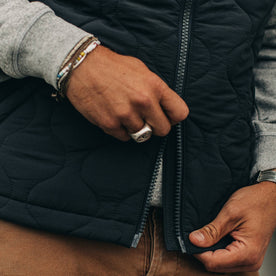 our fit model wearing The Vertical Vest in Charcoal—cropped zipper shot