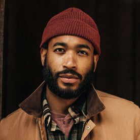 fit model wearing The Rib Beanie in Burgundy Heather, looking into camera