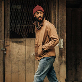 fit model wearing The Rib Beanie in Burgundy Heather, hands in pockets