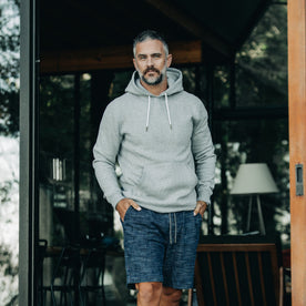 our fit model wearing The Heavy Bag Hoodie in Heather Grey Fleece from the front with hands in pocket