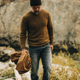 our fit model wearing The Lodge Sweater in Ochre—walking near creek