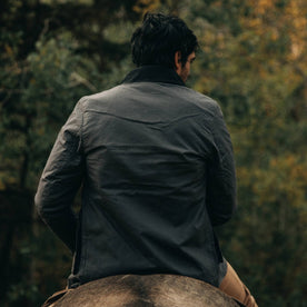 fit model wearing The Rover Jacket in Ripstop Slate Dry Wax, back on horse