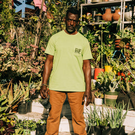 fit model wearing The Heavy Bag Tee in Chlorophyll in the garden