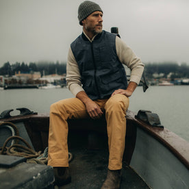 fit model wearing The Anchorage Vest in Charcoal Dry Wax on a boat