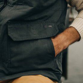 fit model with hand in side pocket of The Anchorage Vest in Charcoal Dry Wax