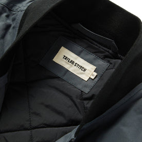 material shot showing interior label of The Anchorage Vest in Charcoal Dry Wax