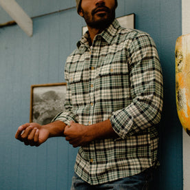 fit model rolling up sleeve of The Ledge Shirt in Blue Plaid